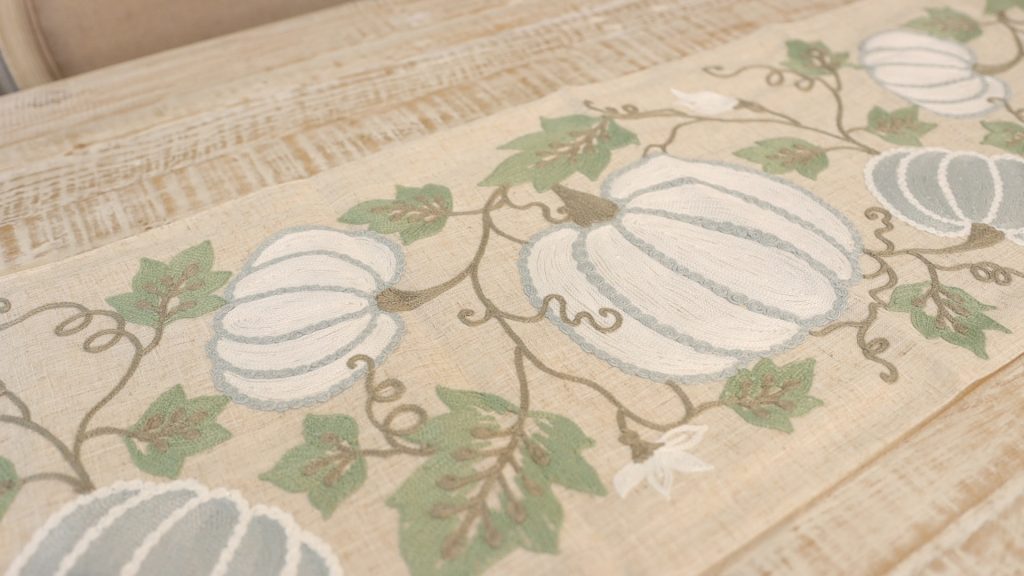 Embroidered pumpkin and fall leaf details on a fall table runner found at Village Antiques, by Amitha Verma.